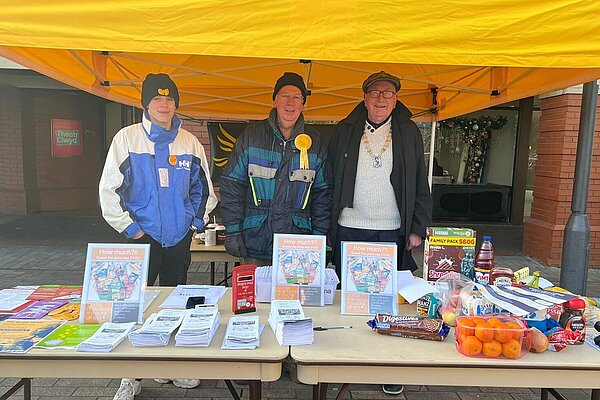 3 campaigners on the stall at Mold market on cost of living issues